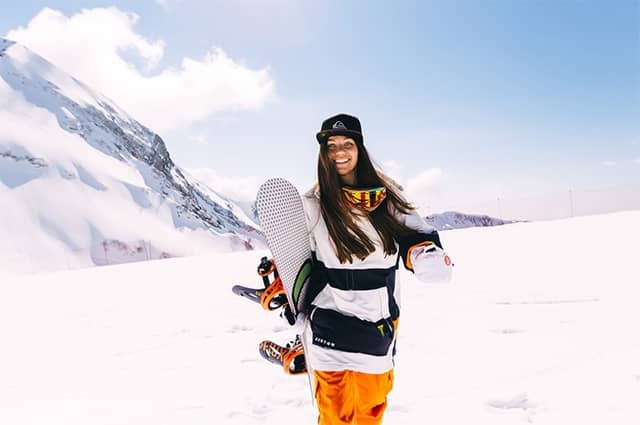 Woman carries snowboard
